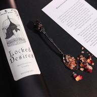 Detailní záběr etikety svíčky Locked Desires s netopýrem uvnitř klece